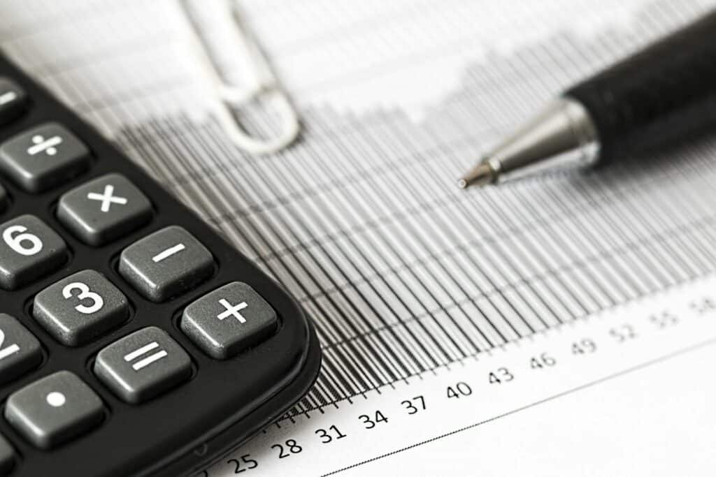 Mastering the Accounting Cycle for Small Business Success 3 Close-up of a calculator and pen on a bar graph, representing finance and accounting.