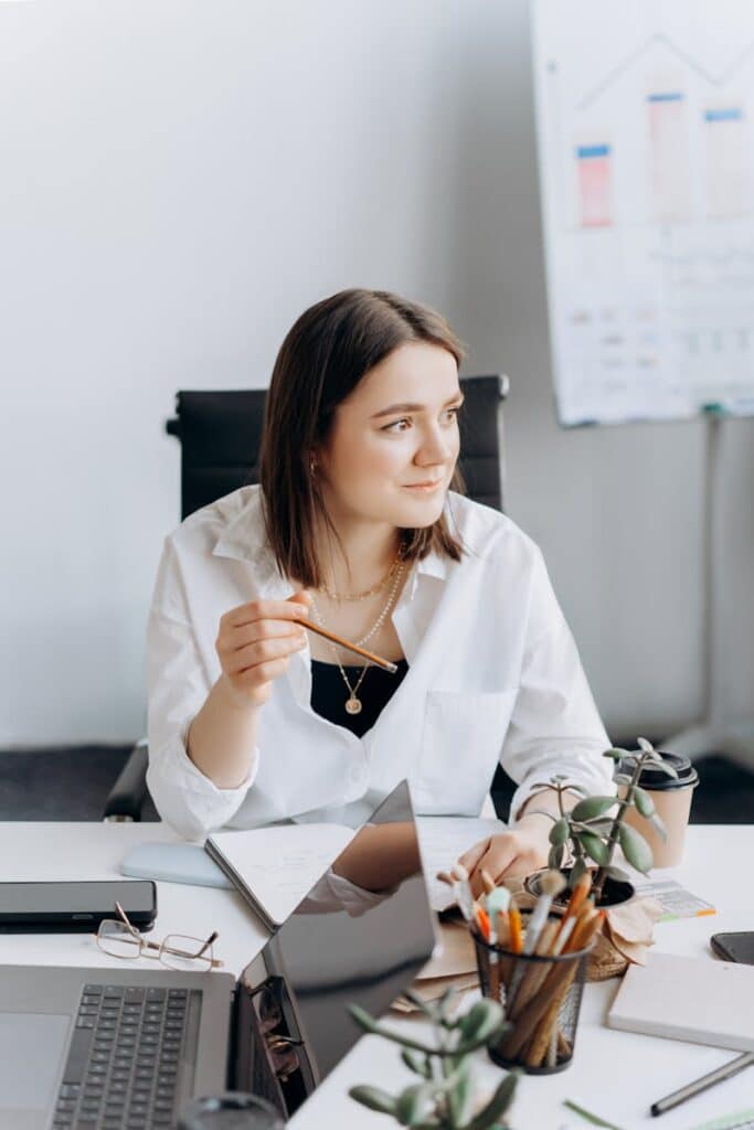 Maximize Your Growth with Expert CFO Services for Small Businesses 1 Businesswoman sits thoughtfully at desk with laptop and notes, projecting success and focus.
