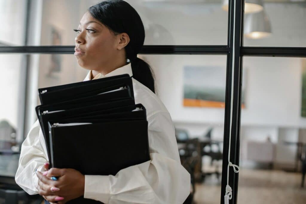 Top Bookkeeping Services for Small Businesses 1 A confident black woman holding files, standing in a modern office environment.